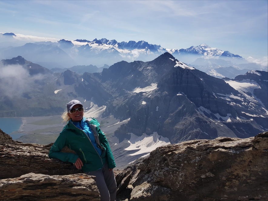 Le Tour des Dents du Midi via le lac d'Emosson Amélie pose en altitude devant la chaîne de montagne et le lac en contrebas